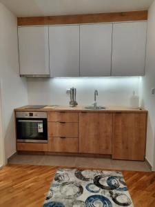 eine Küche mit Holzschränken und einem Waschbecken in der Unterkunft Apartman Matija in Pale