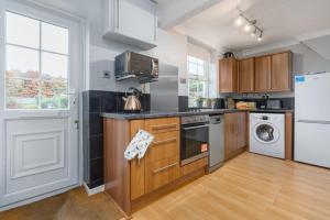 a kitchen with a stove top oven next to a window at Finest Retreats - Poppy Cottage in Docking