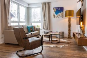 - un salon avec un canapé et une chaise dans l'établissement Der Gletscherblick by Alpin Rentals, à Kaprun