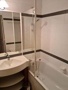 a bathroom with a sink and a tub and a mirror at Appartement en résidence ete/hiver piscine in Valmeinier