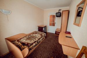 Zimmer mit einem Bett, einem Schreibtisch und einem TV in der Unterkunft ПОДІЛЛЯ in Winnyzja