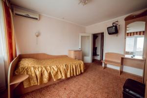 1 dormitorio con 1 cama y TV en ПОДІЛЛЯ, en Vínnytsia