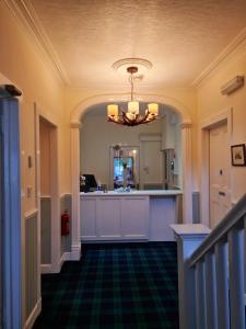 a hallway of a home with a kitchen and a chandelier at Atholl House Skye in Dunvegan