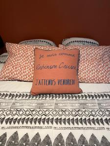 a bed with a pillow with a sign on it at Studio Cosy tt confort proche aéroport in Colombier-Saugnieu