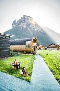ein Haus mit einem Berg im Hintergrund in der Unterkunft Schlafen im Fass - Schlaffass - Abenteuer - Romantik - Haslifass in Innertkirchen