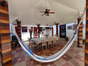 a hammock in a living room with a table and chairs at Las Catalinas Anton Panama in Antón