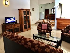 a living room with a couch and a coffee table at Garden Haven Hikkaduwa in Hikkaduwa