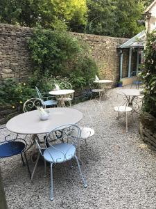 een groep tafels en stoelen in een tuin bij Lucy's Tearoom in Stow on the Wold