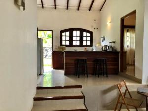 a kitchen with a counter and a bar with stools at Garden Haven Hikkaduwa in Hikkaduwa