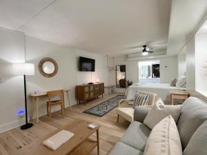 una sala de estar con un sofá y una cama en Just Shy of the Bridge - Waterway Condo 110, en Wilmington