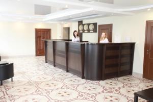 twee vrouwen aan een bar in een hotelkamer bij Troya Hotel in Rudny