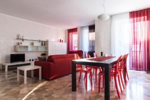 uma sala de estar com um sofá vermelho e uma mesa e cadeiras em La casa di Cri sul Naviglio em Milão