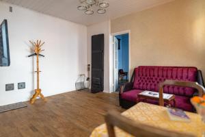 a living room with a red couch and wooden floors at Campenhausen lodging in the heart of Kuressaare in Kuressaare