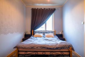 a bedroom with a bed with a window and a bed frame at Campenhausen lodging in the heart of Kuressaare in Kuressaare