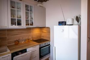 a kitchen with white cabinets and a white refrigerator at Campenhausen lodging in the heart of Kuressaare in Kuressaare