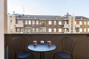 un tavolo e due sedie su un balcone con un edificio di La casa di Cri sul Naviglio a Milano