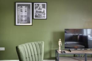 a living room with a green chair and a television at Cosy Chelmsford Apartment - Free Allocated Parking in Chelmsford +10 photos