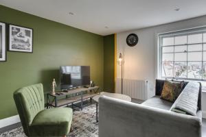 a living room with a couch and a tv at Beautiful Chelmsford Apartment in Chelmsford