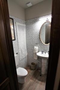 bagno con servizi igienici, lavandino e specchio di La casa dell' artista a Torino
