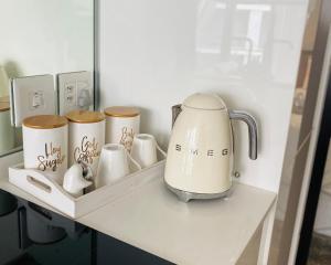 a coffee pot and cups on a shelf at Waterfall Views From The Six- Luxurious Apartment in Midrand