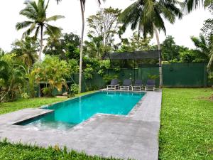 a swimming pool in the yard of a villa at Garden Haven Hikkaduwa in Hikkaduwa