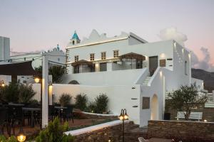 a white building with a restaurant in front of it at Ursa Major Suites in Tinos