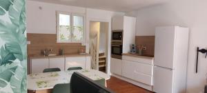 a kitchen with a table and a white refrigerator at Duplex - En plein Centre Ville - 4 adultes et 2 enfants in Dieppe
