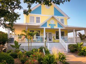 a yellow and blue house with a porch at Sun Outdoors Ocean City in Ocean City