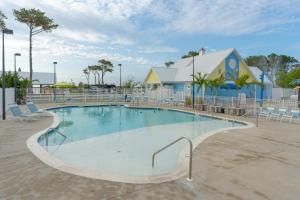 a swimming pool at a resort with chairs and a building at Sun Outdoors Ocean City in Ocean City
