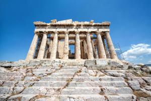 ein hohes Gebäude mit Säulen auf einer Steintreppe in der Unterkunft Acropolis Select Flat in Athen