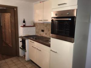 a kitchen with white cabinets and a stove top oven at Ferienwohnung Oberlechner in Anger
