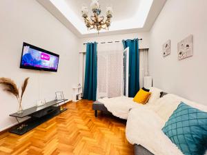 een woonkamer met een bank en een flatscreen-tv bij Acropolis Select Flat in Athene