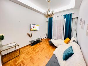 ein Wohnzimmer mit einer Couch und einem Kronleuchter in der Unterkunft Acropolis Select Flat in Athen