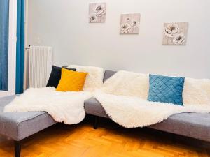 eine Couch mit Kissen darauf in einem Wohnzimmer in der Unterkunft Acropolis Select Flat in Athen