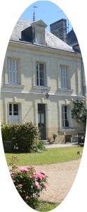 una gran casa blanca con flores delante en La Pénesais, en Beaumont-en-Véron