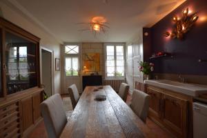 a dining room with a wooden table and a sink at La Pénesais in Beaumont-en-Véron