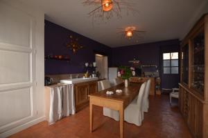 una cocina con una mesa con manteles blancos. en La Pénesais, en Beaumont-en-Véron