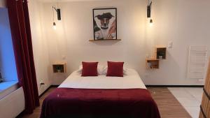 a bedroom with a large bed with red pillows at Hôtel La Bonaventure Jezainville in Jezainville