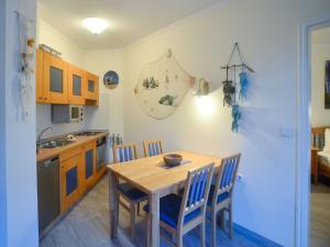 a kitchen with a wooden table and chairs at Dünenpark Binz - Komfort Ferienwohnung mit 1 Schlafzimmer und Balkon im Dachgeschoss 282 in Binz