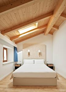 una camera da letto con un grande letto e soffitti in legno di Crocevia - Locanda carsica contemporanea a Trieste