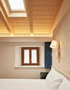 a bedroom with a bed and a window at Crocevia - Locanda carsica contemporanea in Trieste