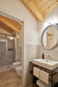 a bathroom with a sink and a toilet and a mirror at Crocevia - Locanda carsica contemporanea in Trieste