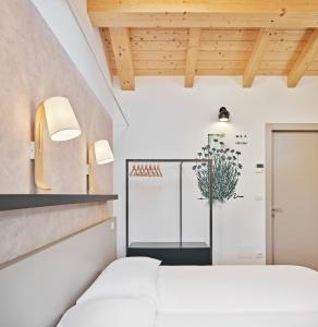 a room with a bed and a refrigerator at Crocevia - Locanda carsica contemporanea in Trieste