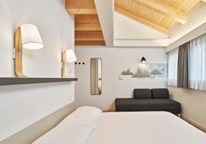 a hotel room with two beds and a chair at Crocevia - Locanda carsica contemporanea in Trieste