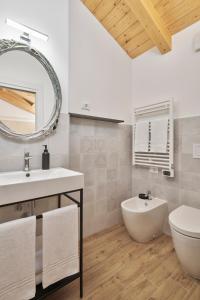 a bathroom with a sink and a toilet and a mirror at Crocevia - Locanda carsica contemporanea in Trieste