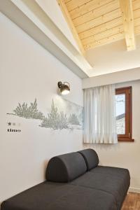 a bedroom with a black bed and a window at Crocevia - Locanda carsica contemporanea in Trieste