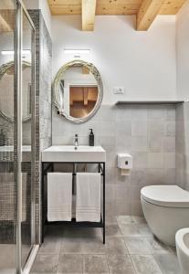 a bathroom with a toilet sink and a mirror at Crocevia - Locanda carsica contemporanea in Trieste