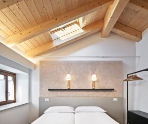 a bedroom with a bed and a skylight at Crocevia - Locanda carsica contemporanea in Trieste