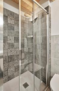a glass shower with a toilet in a bathroom at Crocevia - Locanda carsica contemporanea in Trieste
