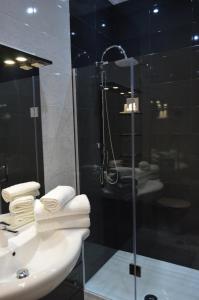a bathroom with a sink and a shower with towels at Hôtel Timgad in Gérardmer